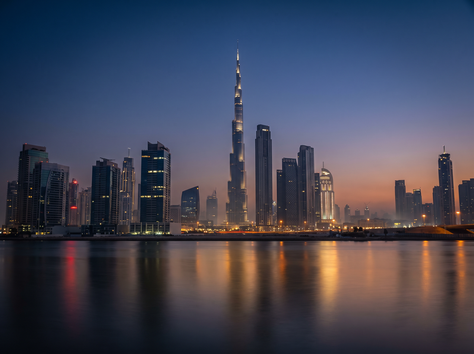 Downtown Dubai and the Burj Khalifa at blue hour, reflected in the water